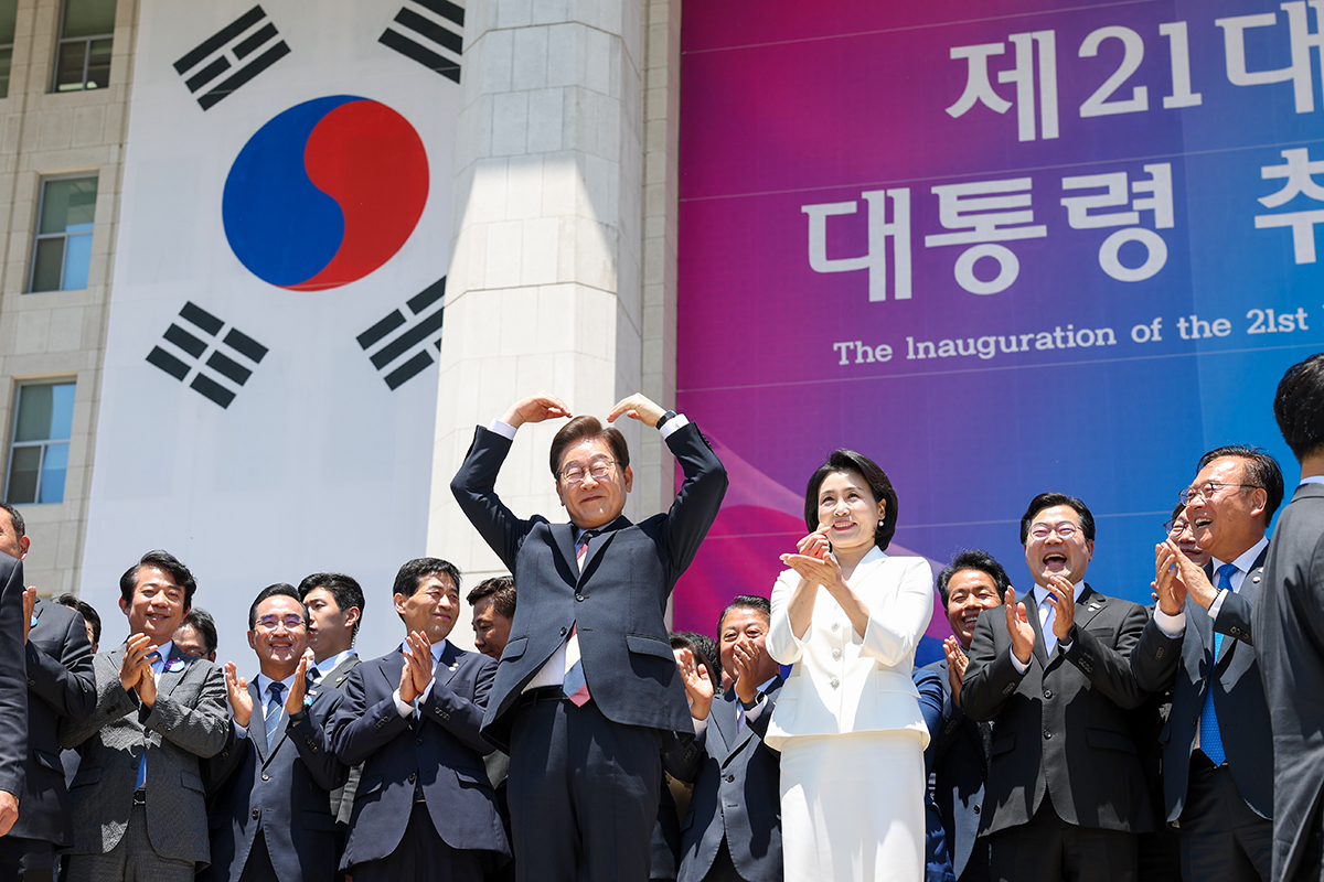 Presiden Lee Jae Myung dan Ibu Negara Kim Hea Kyung membuat gestur hati kepada warga usai upacara pelantikan yang digelar di Majelis Nasional pada tanggal 4 Juni 2025. (Lee Jeong Woo)