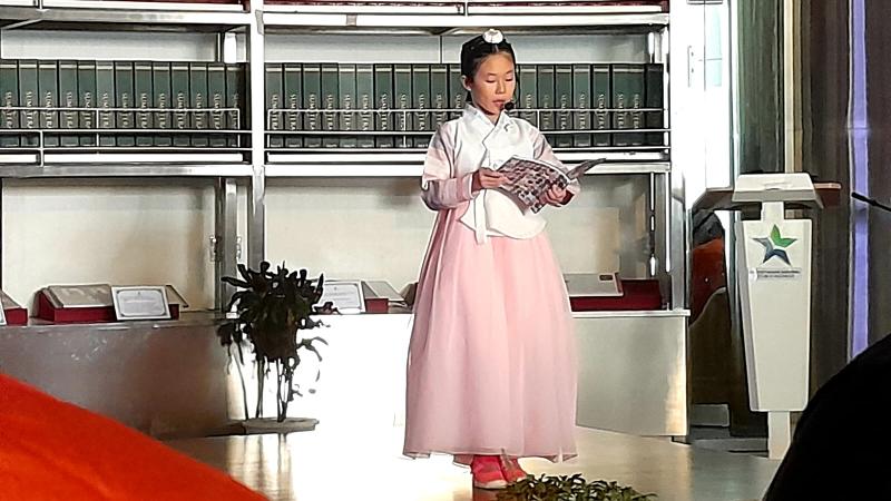 Pelajar Korea bernama Lee Seol sedang membacakan cerita dongeng Indonesia berjudul Bawang Merah Bawang Putih dalam bahasa Indonesia. 