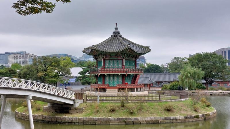 Potret Paviliun Hyangwonjeong, paviliun berbentuk heksagonal di tengah kolam yang berada di bagian terdalam Gyeongbokgung. 