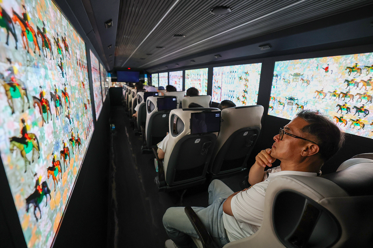 Para pengunjung Pameran Wisata Internasional Seoul terlihat sedang mencoba XR Bus Bound For 1795 yang dipamerkan dalam pameran tersebut pada tanggal 4 Juni 2026 di COEX, Gangnam-gu, Seoul. Bus tersebut merupakan bus khusus yang dilengkapi dengan realitas berimbuh (AR) dan realitas virtual (VR) untuk melihat prosesi kerajaan Raja Jeongjo yang digelar pada tahun 1795. (Lee Jeong Woo)