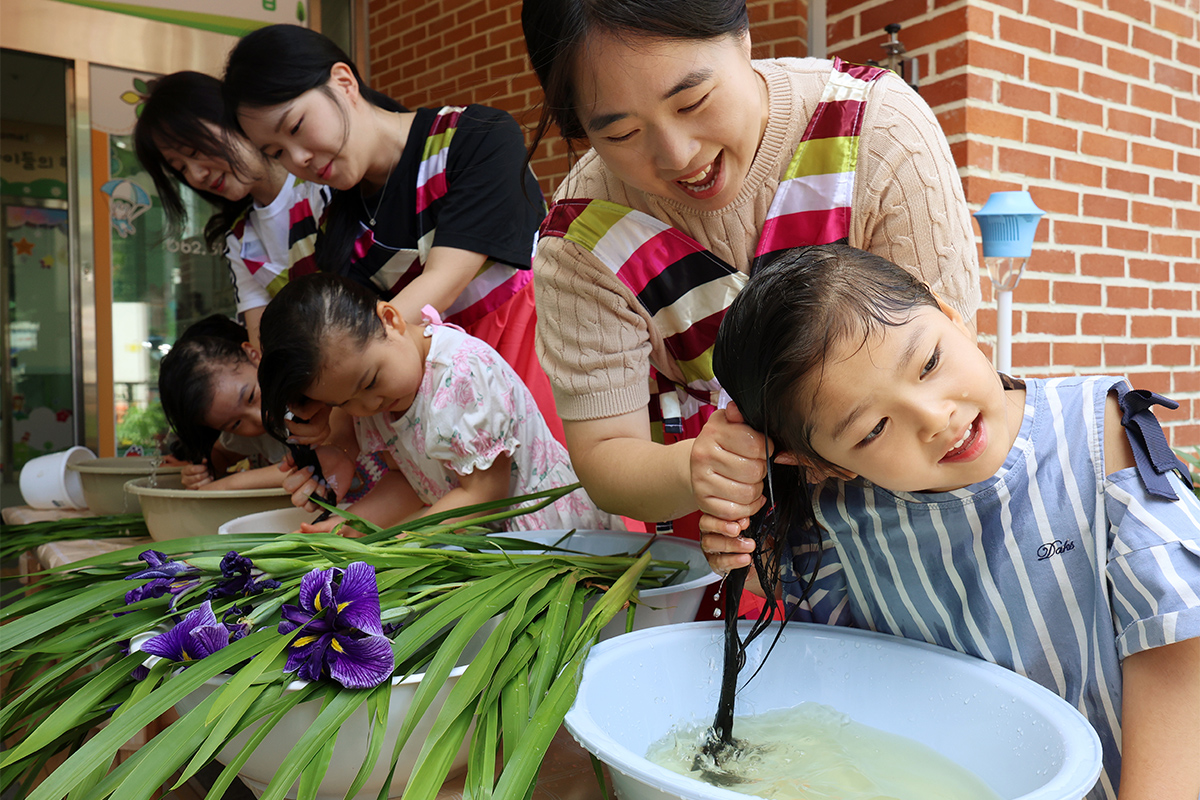Dua hari menjelang perayaan Dano (hari kelima bulan kelima dalam kalender lunar), pada tanggal 17 Juni 2026, anak-anak dari pusat penitipan anak Kantor Buk-gu di Gwangju mencuci rambut dengan air changpo (tanaman herbal tradisional Korea) sambil berharap diberi kesehatan, umur panjang, dan terhindar dari bala. (Yonhap News)