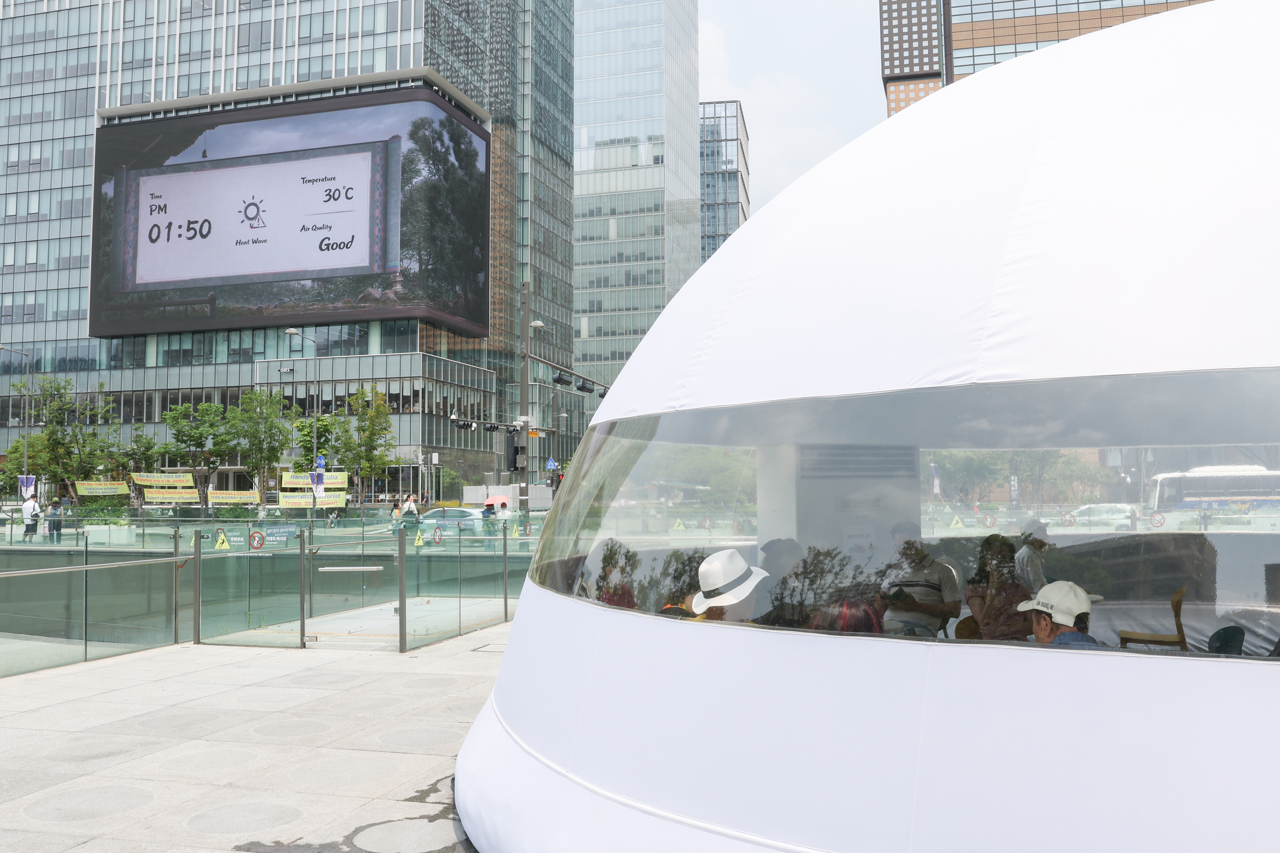 Warga terlihat sedang beristirahat dalam sebuah fasilitas pendinginan udara yang dipasang di tengah Alun-alun Gwanghwamun, Seoul. Peringatan gelombang panas diterbitkan pada saat foto tersebut dipotret tanggal 30 Juni 2026. (Park Daejin)