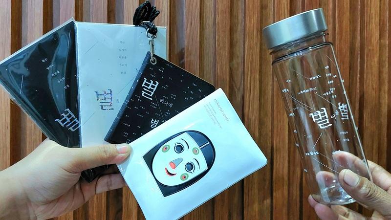 Potret sampul paspor berilustrasikan topeng tradisional Korea dan potongan naskah puisi Yoon Dongju yang diadaptasi ke dalam berbagai bentuk suvenir. 