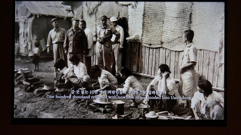 Potret ini merupakan cuplikan video dokumentasi tentang pengusngsi yang berada di Uam-dong yang dipajang pada pameran khusus Warisan Busan sebagai Ibu Kota Sementara pada Masa Pengungsian di Museum Sejarah Modern dan Kontemporer Busan. 
