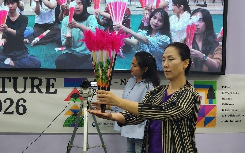 Song Mhin Suk sedang mempraktikan cara memegang kipas yang benar pada hari pertama (17/06/2026) program SCA berlangsung di King Sejong Institute Surabaya. 