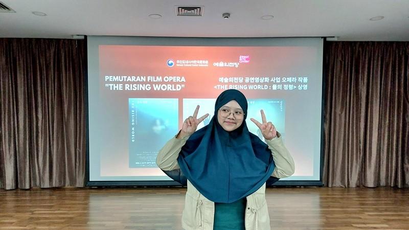 Penulis berfoto di depan layar yang menampakkan poster acara pemutaran film opera The Rising World: Spirit of Water seusai acara. (Maulia Resta Mardaningtias)