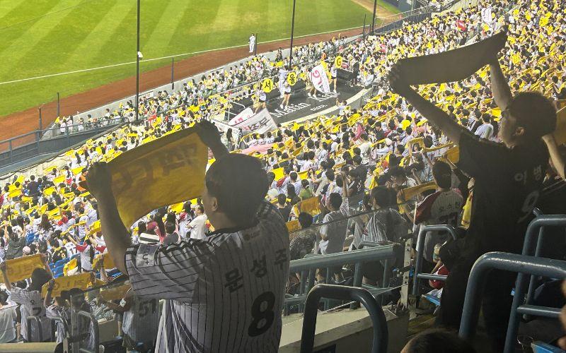 Pemandu sorak memimpin ribuan penonton menyanyikan lagu penyemangat di tribun saat pertandingan liga KBO berlangsung pada hari Kamis (16/7/2026) antara LG Twins dan kt wiz di Stadion Jamsil, Seoul. 