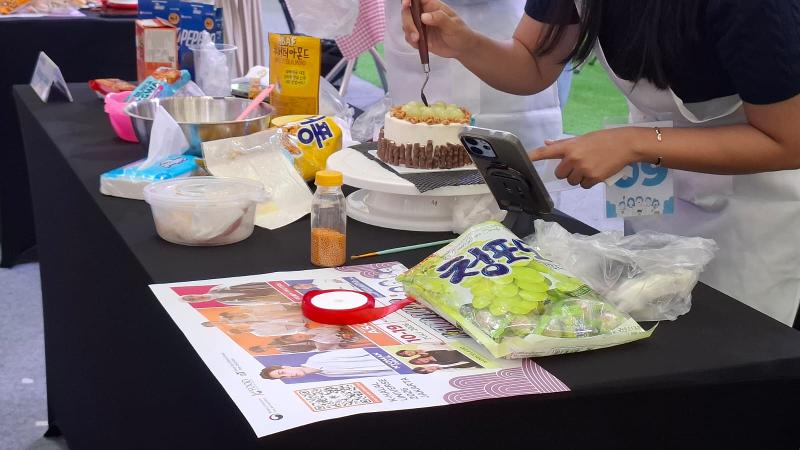 Potret salah seorang anggota tim sedang menghias kue mereka dengan aneka kudapan Korea pada K-Dessert Decoration Contest tanggal 19 Juli 2026 di Mal Kota Kasablanka, Jakarta. 