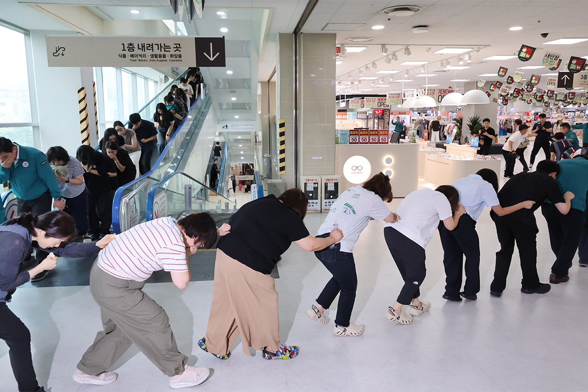 Simulasi evakuasi pertahanan sipil untuk menghadapi serangan udara dalam rangka Latihan Ulchi digelar pada tanggal 20 Agustus 2026 di sebuah supermarket yang berada di Busanjin-gu, Kota Busan. Setelah peringatan serangan udara dibunyikan, seluruh petugas kantor distrik, karyawan pusat perbelanjaan, dan pengunjung mengikuti arahan untuk mengungsi. (Yonhap News)