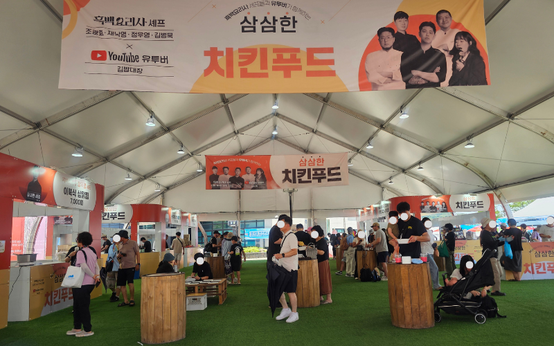 Salah satu stan makanan yang berkolaborasi dengan pemengaruh kuliner yang menjadi salah satu daya tarik kuliner Festival Samgyetang Geumsan pada tanggal 11 Juli 2026 di Geumsan, Provinsi Chungcheongnam.  