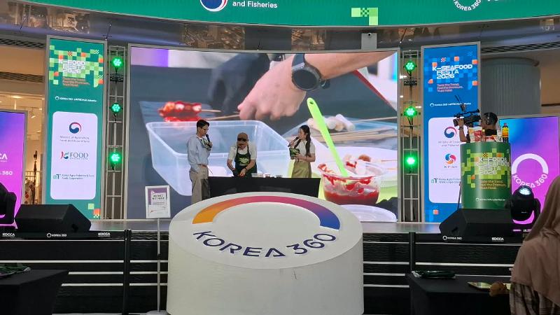 Okky Ho menyajikan sotteok sotteok yang telah dioleskan saus pedas manis pada K-Food & K-Seafood Experience tanggal 16 Agustus 2026 di KOREA 360, Jakarta. 