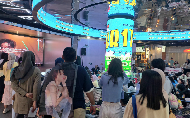 Para penggemar K-Pop menikmati program noraebang (karaoke) yang dilaksanakan pada tanggal 9 Agustus 2026 di area panggung Lotte Alley, Jakarta. 