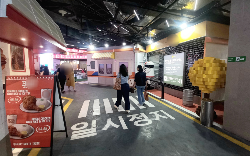 Potret suasana instalasi bernuansa jalanan Korea di Lotte Alley, Jakarta, dengan berbagai ornamen bertuliskan hangeul dan deretan toko di sisi jalan pada tanggal 15 Agustus 2026.  
