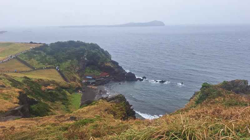 Jalan turun menuju Pantai Umutgae, tempat pertunjukan haenyeo dilaksanakan. Selain itu juga terdapat rumah makan olahan laut di sekitarnya. Foto tersebut diambil pada 15 Agustus 2026.  