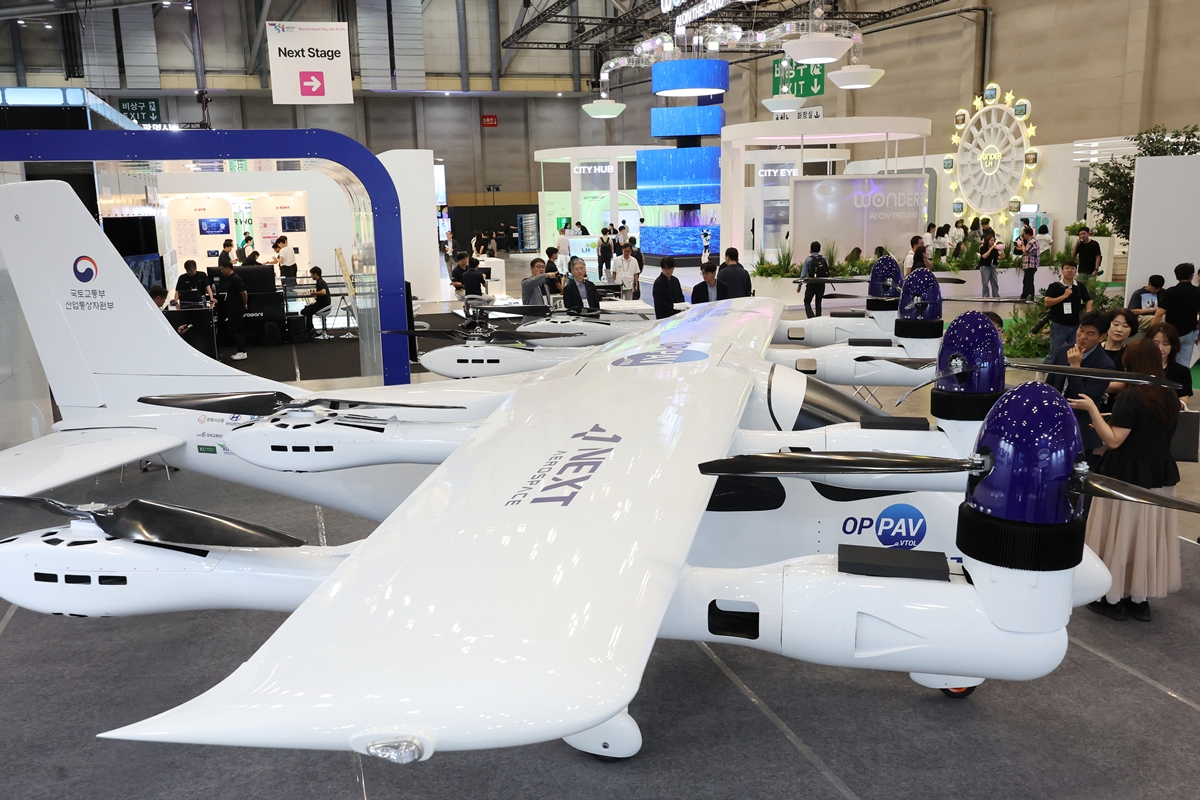  Pengunjung mengamati pesawat nirawak VTOL bermanuver tinggi yang dirancang untuk pengerahan cepat serta prototipe pesawat VTOL berpropulsi terdistribusi berkapasitas satu orang yang dapat dioperasikan dengan atau tanpa pilot.     Pesawat-pesawat tersebut dipamerkan dalam Pameran Kota Pintar Sedunia yang digelar mulai tanggal 9 September 2026 di BEXCO, Haeundae-gu, Busan.     Acara yang berlangsung hingga tanggal 11 September 2026 tersebut diikuti oleh 277 perusahaan yang menampilkan teknologi dan layanan kota pintar di bidang kecerdasan buatan, transportasi dan mobilitas, perumahan, energi dan lingkungan, serta keamanan dan penanggulangan bencana. (Yonhap News)