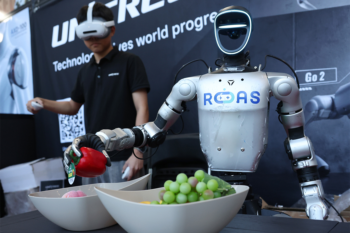 Sebuah robot humanoid memperagakan kemampuannya mengambil benda dengan menggerakkan sendi-sendi jarinya sambil mengikuti gerakan manusia di salah satu stan di luar lokasi acara Humanoid Summit 2026 Seoul yang digelar di COEX, Gangnam-gu, Seoul, pada tanggal 22 September 2026. (Yonhap News)