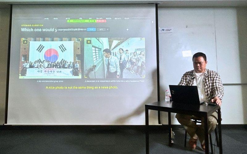 Jurnalis foto Ha Sang-yun dari The Hankook Ilbo hadir sebagai narasumber memberikan penjelasan mengenai perbedaan antara foto jurnalistik dan foto biasa pada Sabtu (29/8/2026) di IGM Global Management Institute, Jung-gu, Seoul. 