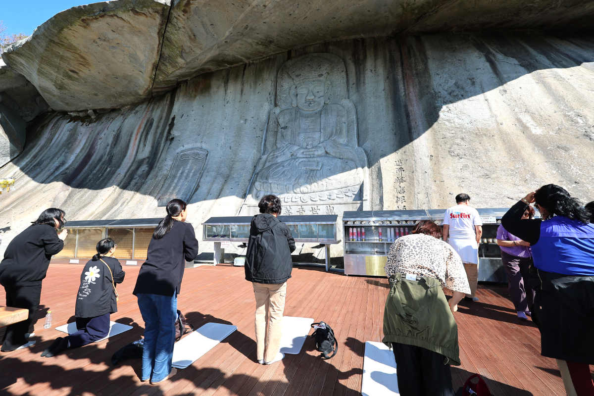 Para orang tua dan umat Buddha berdoa pada tanggal 20 Oktober 2026 di depan patung Buddha di Kuil Bomunsa, Ganghwa-gun, Incheon. Mereka mendoakan keberhasilan para siswa dalam ujian masuk perguruan tinggi tahun ajaran 2027 yang akan digelar pada 19 November 2026. (Yonhap News)