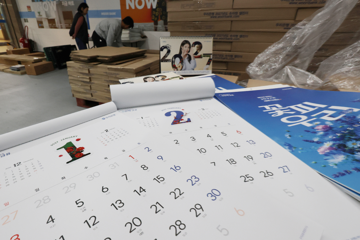 Pada tanggal 28 Oktober 2026, sekitar dua bulan menjelang 2027, para petugas menata kalender untuk tahun depan di kantor pusat Woori Bank di Jung-gu, Seoul. (Yonhap News)
