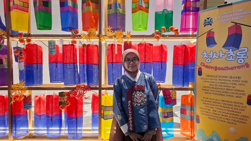 Penulis berfoto mengenakan hanbok dengan latar belakang lentera Korea untuk memeriahkan perayaan Chuseok pada K-Fandom Chuseok Super Match yang digelar KCCI dan CoppaMagz tanggal 26 September 2026 di Mal Agora, Jakarta.  