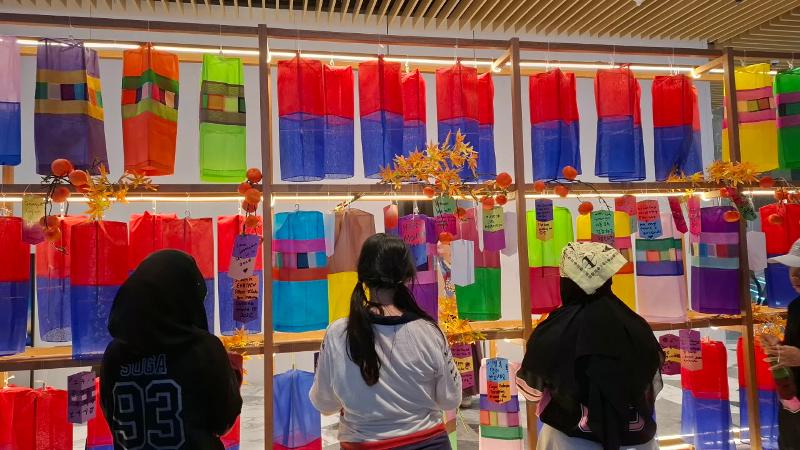 Potret para pengunjung menggantung catatan harapan mereka di stan KCCI pada K-Fandom Chuseok Super Match tanggal 26 September 2026 di Mal Agora, Jakarta. 