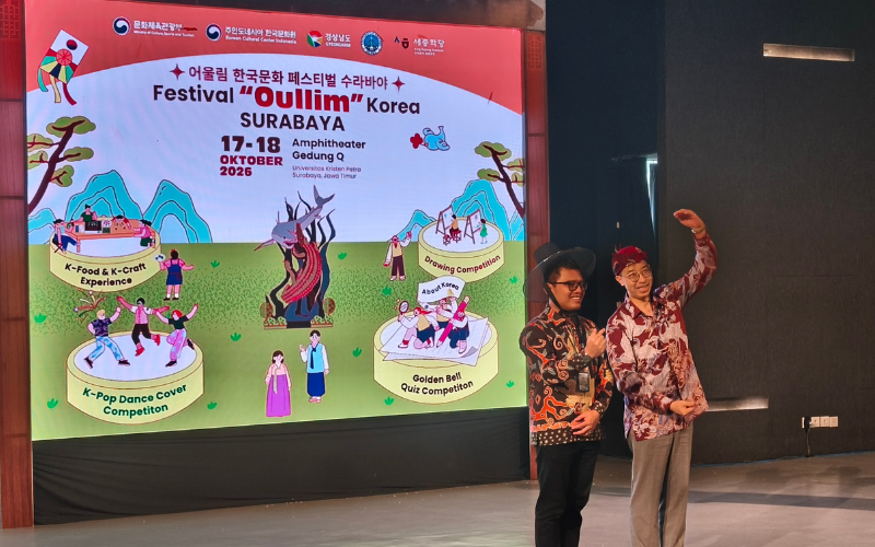 Kabid Budaya Disbudporapar Surabaya Ridzolatullahmad Nurchakim (kiri) mengenakan gat (topi tradisional Korea) dan Konsul Jenderal Kedutaan Besar Korea Kang Won-jun (kanan) mengenakan belangkon sebagai simbol pertukaran budaya sekaligus pembukaan Festival Oullim Korea pada hari Sabtu (17/10/2026) di Universitas Kristen Petra, Surabaya. 